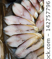 Dry aged mackerel in layered slices presented in a neat and appealing arrangement on a seafood display at a fish market 142757796