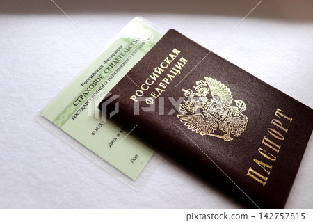 A Russian passport resting on a state pension insurance certificate A Russian passport resting on a state pension insurance certificate 142757815