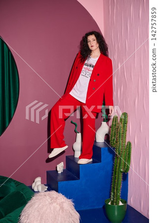 Female in vibrant red jumpsuit descending blue staircase energetically Female in vibrant red jumpsuit descending blue staircase energetically 142757859