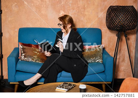 Confident woman in formal attire conducting remote interview indoors Confident woman in formal attire conducting remote interview indoors 142757881