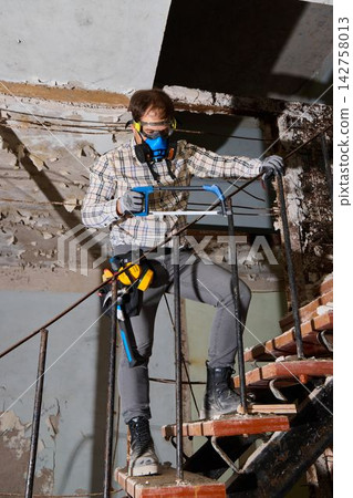 Construction professional carefully dismantles urban staircase structure Construction professional carefully dismantles urban staircase structure 142758013