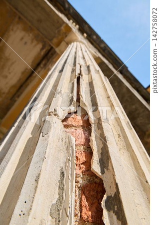 Closeup of weathered structure showing peeling plaster and exposed bricks Closeup of weathered structure showing peeling plaster and exposed bricks 142758072