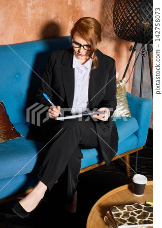 Individual engaged in detailed review of documents and files Individual engaged in detailed review of documents and files 142758073