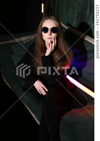 Cheerful woman enjoying vibrant ambiance with sunglasses and neon glow Cheerful woman enjoying vibrant ambiance with sunglasses and neon glow 142758237