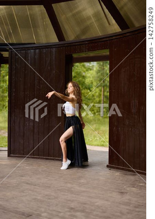Elegant ballet student caucasian stretching in doorway Elegant ballet student caucasian stretching in doorway 142758249