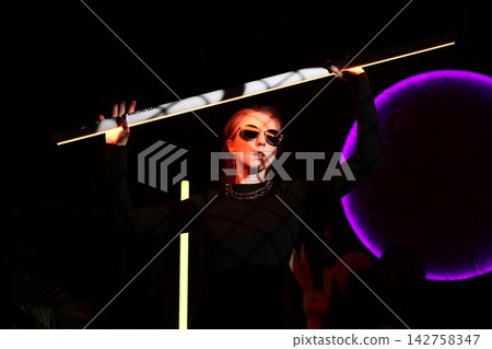 Lively entertainer showcasing colorful lighting and dynamic stance Lively entertainer showcasing colorful lighting and dynamic stance 142758347