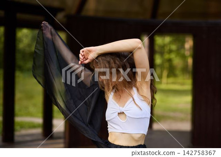 Serene woman performing dance amidst tranquil forest surroundings Serene woman performing dance amidst tranquil forest surroundings 142758367