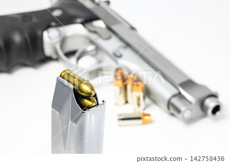 bullet 9mm FMJ (Full Metal Jacketed)  in magazines and 9mm postal gun in background. 142758436
