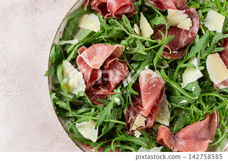 Fresh arugula salad with prosciutto and grated parmesan cheese, on a plate, homemade, no people, Fresh arugula salad with prosciutto and grated parmesan cheese, on a plate, homemade, no people, 142758585
