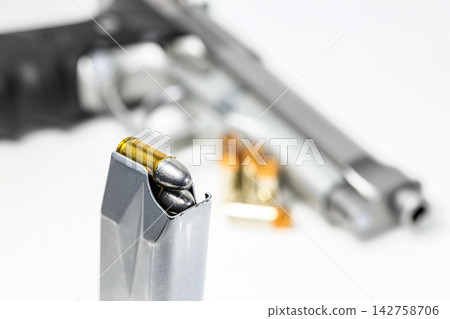 bullet 9mm parabellum LRN ( lead round nose ) in magazines and 9mm postal gun in background. bullet 9mm parabellum LRN ( lead round nose ) in magazines and 9mm postal gun in background. 142758706