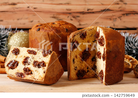 Sliced special Christmas panettone with chocolate filling on handcrafted wooden table. 142759649
