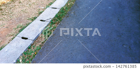 Asphalt Road with Concrete Drainage Gutter and Grass Edge Asphalt Road with Concrete Drainage Gutter and Grass Edge 142761385
