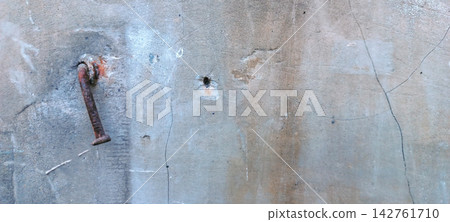 Weathered Concrete Wall with Rusty Anchor Hook and Cracks Weathered Concrete Wall with Rusty Anchor Hook and Cracks 142761710