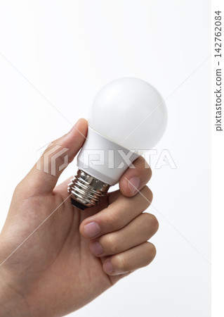 拿著 LED 燈泡的男手 拿著 LED 燈泡的男手 142762084