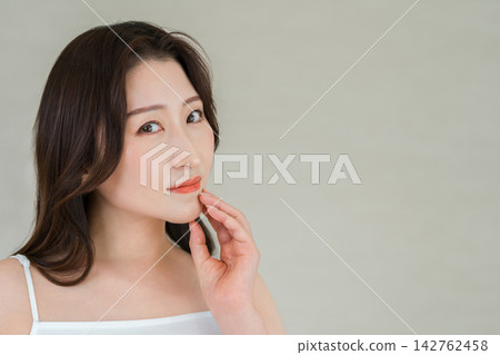 一位四五十歲的女性將手放在下顎線上。這幅畫面展現了抗老護理和美麗肌膚。 一位四五十歲的女性將手放在下顎線上。這幅畫面展現了抗老護理和美麗肌膚。 142762458
