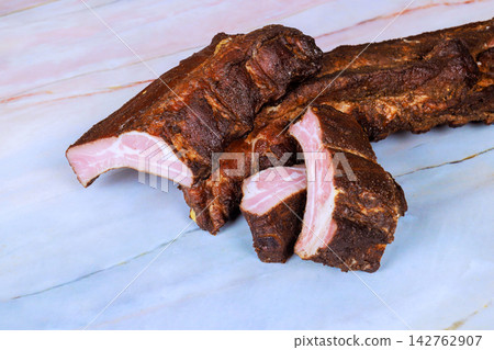 Cooked meat pieces displayed on light marble surface with visible seasoning Cooked meat pieces displayed on light marble surface with visible seasoning 142762907