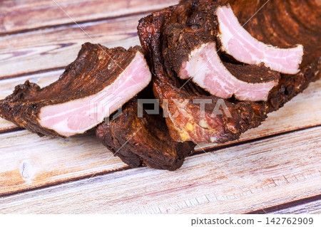 Sliced cured meat resting on wooden surface ready for serving 142762909