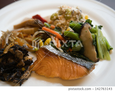 飯店早餐包括烤鮭魚和日式蔬菜小菜。 飯店早餐包括烤鮭魚和日式蔬菜小菜。 142763143