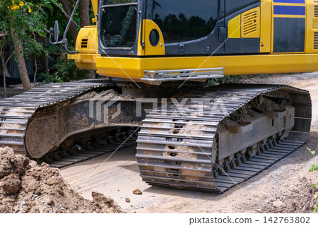 Heavy tracked excavator standing dirt at construction site showing steel crawler tracks machinery used for excavation earthmoving ground development 142763802