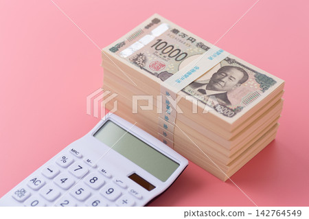 一疊700萬日元鈔票和一個白色計算器,背景是粉紅色的。 一疊700萬日元鈔票和一個白色計算器,背景是粉紅色的。 142764549