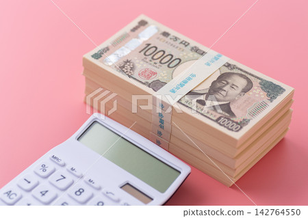 一疊500萬日元鈔票和一個白色計算器,背景是粉紅色的。 一疊500萬日元鈔票和一個白色計算器,背景是粉紅色的。 142764550