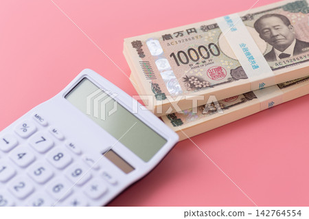 一疊200萬日元鈔票和一個白色計算器,背景是粉紅色的。 一疊200萬日元鈔票和一個白色計算器,背景是粉紅色的。 142764554