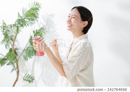 一位女士喝果汁後感覺精力充沛 一位女士喝果汁後感覺精力充沛 142764698