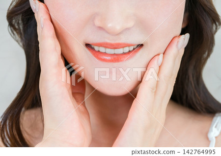 一張展現女性口腔護理的圖片,女性年齡在 40 到 50 歲之間,擁有潔白健康的牙齒和美麗的笑容。 一張展現女性口腔護理的圖片,女性年齡在 40 到 50 歲之間,擁有潔白健康的牙齒和美麗的笑容。 142764995