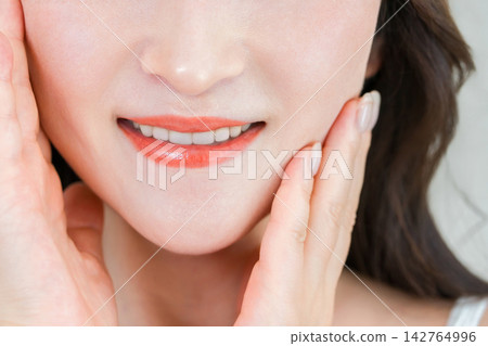 A woman in her 40s or 50s with a beautiful smile and striking white teeth. An image of beautiful skin and oral care. A woman in her 40s or 50s with a beautiful smile and striking white teeth. An image of beautiful skin and oral care. 142764996