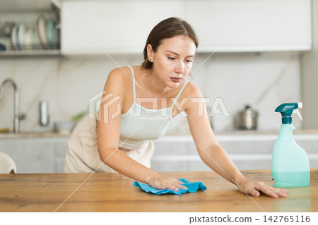 Adult woman in shorts cleaning kitchen Adult woman in shorts cleaning kitchen 142765116