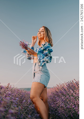 Woman lavender sunset enjoying a glass of water in a blooming field under a clear blue sky during golden hour Woman lavender sunset enjoying a glass of water in a blooming field under a clear blue sky during golden hour 142765166