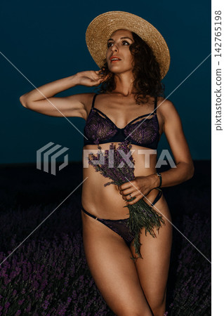 Lavender woman hat portrait standing in lavender field holding fresh purple flowers during beautiful summer sunset in rural countryside setting Lavender woman hat portrait standing in lavender field holding fresh purple flowers during beautiful summer sunset in rural countryside setting 142765198