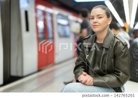Portrait of pretty girl sitting on bench waiting for subway train Portrait of pretty girl sitting on bench waiting for subway train 142765201