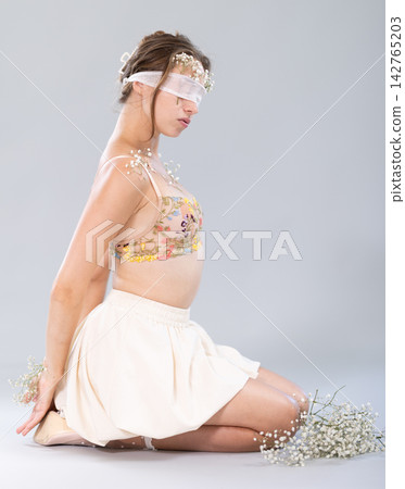 Stunning female model poses blindfolded in studio. Stunning female model poses blindfolded in studio. 142765203