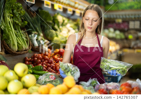 Supermarket employee carefully places beans on shelves of grocery supermarket Supermarket employee carefully places beans on shelves of grocery supermarket 142765307