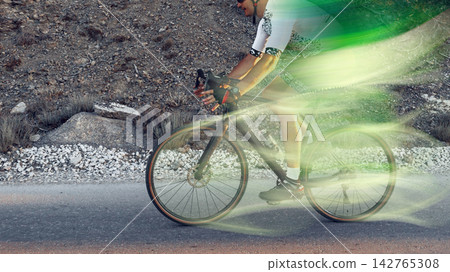 Cyclist riding on a mountain road during the day Cyclist riding on a mountain road during the day 142765308