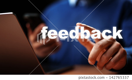 User providing feedback while using a smartphone and laptop in a workspace setting User providing feedback while using a smartphone and laptop in a workspace setting 142765337