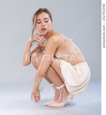 Topless young woman posing in in bright minimalist studio environment 142765390