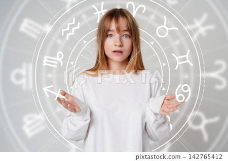 Woman looking confused with zodiac signs in background Woman looking confused with zodiac signs in background 142765412