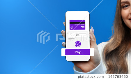 Holding a phone showing online payment process with a visible pay button on a blue background Holding a phone showing online payment process with a visible pay button on a blue background 142765460
