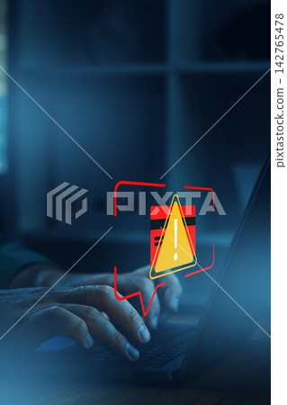 Alert on deepfake technology while a person types on a laptop in a home office setting at night 142765478