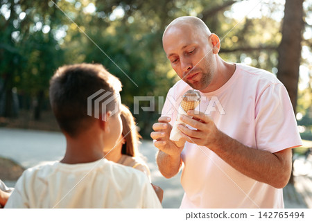 Enjoying ice cream together on a sunny day in the park with kids 142765494
