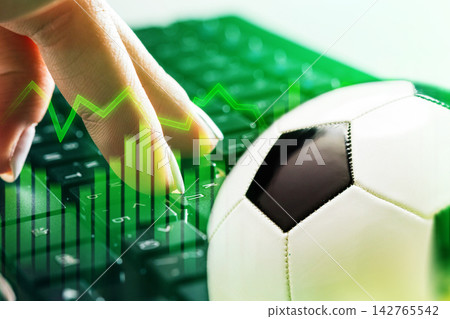 Football betting on a computer with a soccer ball and betting graphs in the background Football betting on a computer with a soccer ball and betting graphs in the background 142765542