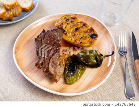 Hot dinner of spiced roast beef with fried potatoes and peppers on white plate. Hot dinner of spiced roast beef with fried potatoes and peppers on white plate. 142765642