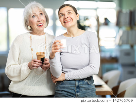 Elderly and adult women laughing and talking during coffee break 142765709