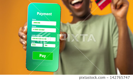 Man shows smartphone screen with payment details and holds credit card with happy expression Man shows smartphone screen with payment details and holds credit card with happy expression 142765747