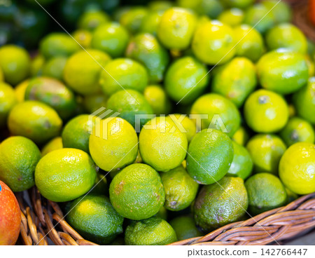 View of limes in a wicker basket, put up for sale in store View of limes in a wicker basket, put up for sale in store 142766447