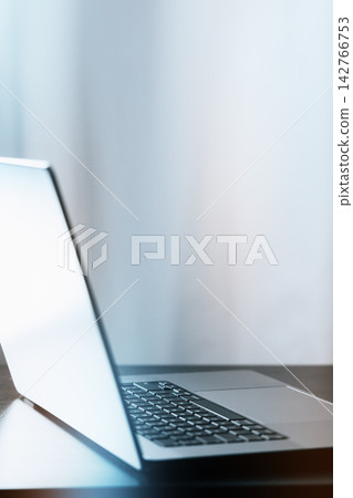 Laptop placed on a table in a workspace with natural light coming through the window Laptop placed on a table in a workspace with natural light coming through the window 142766753