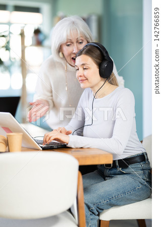 Female mature boss yells at woman employee, staff work at computer Female mature boss yells at woman employee, staff work at computer 142766859