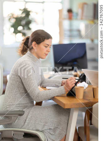 Successful young businesswoman works on an electronic tablet in modern office Successful young businesswoman works on an electronic tablet in modern office 142767095